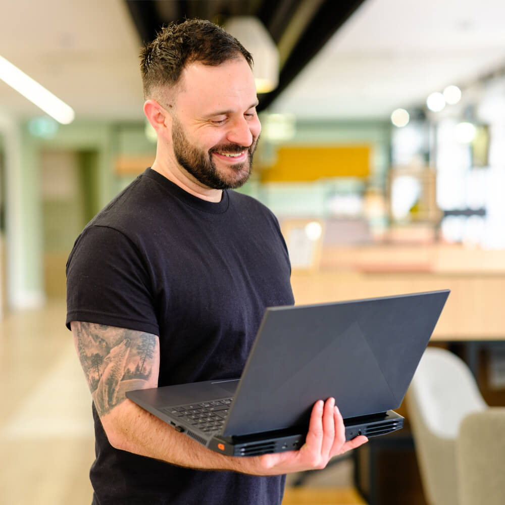 a cyber security expert holding a laptop and smiling a cyber security expert holding a laptop and smiling